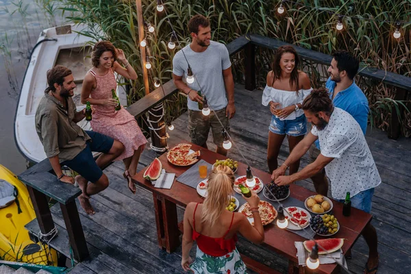 Grupo Jóvenes Teniendo Una Cena Aire Libre Junto Río — Foto de Stock