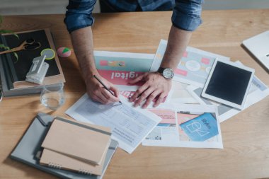 Eller Kafkas işadamı belgeleri incelemek ve modern ofis onun çalışma masasında duran onun tablet kullanma.