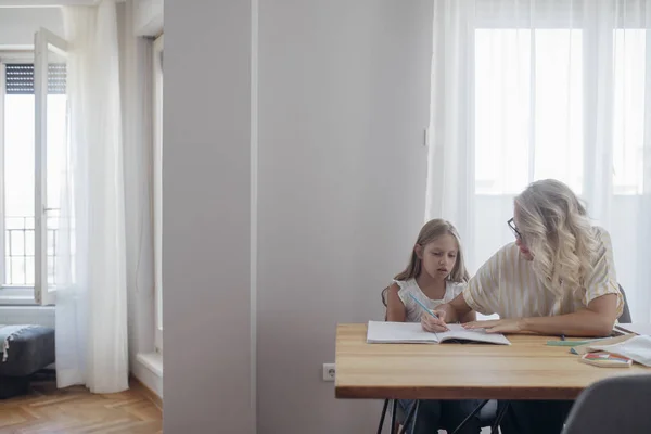 Schattige Blonde Meisje Schrijven Haar Notitieblok Zit Naast Haar Moeder — Stockfoto