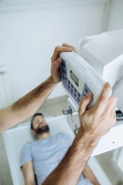 Joven Técnico Médico Operando Una Máquina Rayos Mientras Paciente Está — Foto de Stock