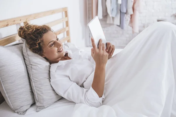 Vrij Lachende Kaukasische Vrouw Liggend Haar Bed Lezen Een Tablet — Stockfoto