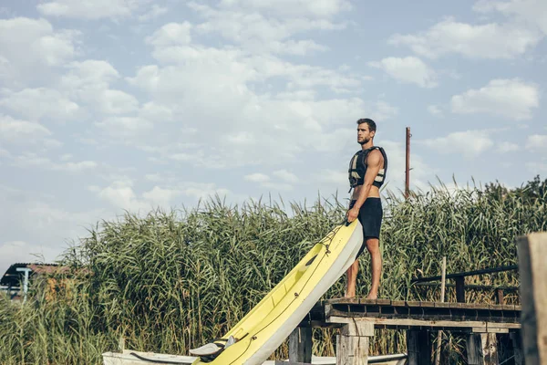 Junger Mann Legt Kajak Ins Wasser Und Trägt Schwimmweste — Stockfoto