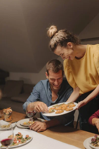 Junge Frau Serviert Leckeres Essen Auf Ihrer Dinnerparty — Stockfoto