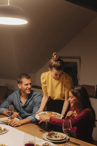 Junge Frau Serviert Leckeres Essen Auf Ihrer Dinnerparty — Stockfoto