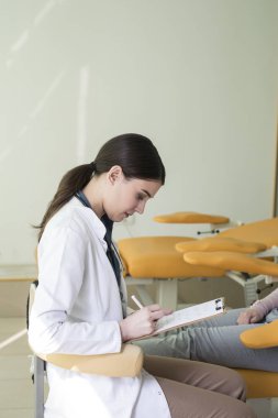 Yazma ve bir hastanın bir anamnez yapma kafkas kadın doktor.