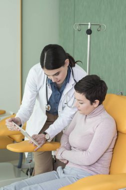 Kadın doktor ve onun hasta tablet vasıl birlikte arıyorsunuz.