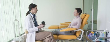 Doktor muayene odasında hastanın anamnez almak oldukça beyaz kadın.