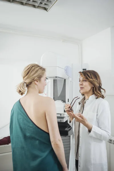 漂亮的白种女人医生与她的病人在乳房检查交谈 — 图库照片