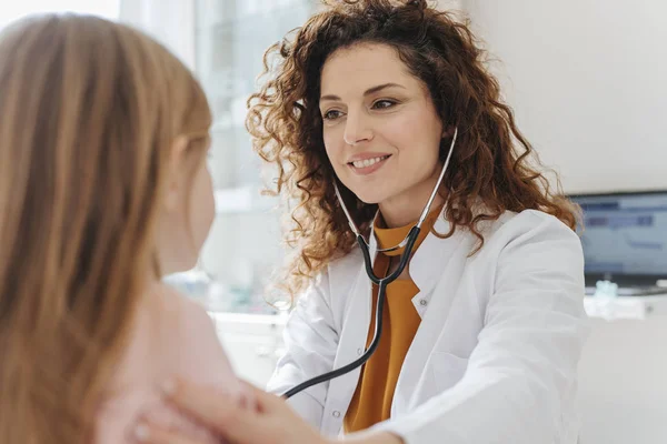 漂亮的微笑白种女人医生检查一个孩子的听诊器 — 图库照片