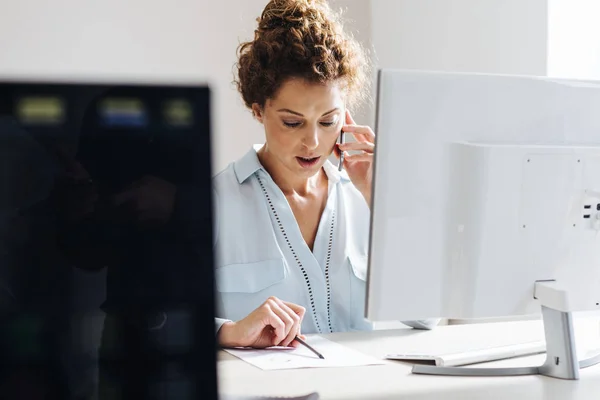 Jovem Empresária Usando Telefone Celular Enquanto Trabalhava Computador Desktop Moderno — Fotografia de Stock