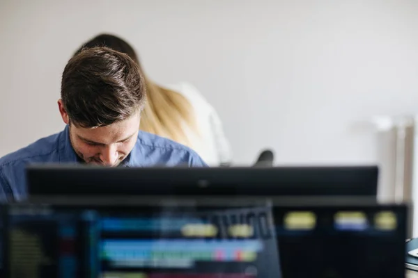 Young businessman working on a desktop computer at the modern office space.