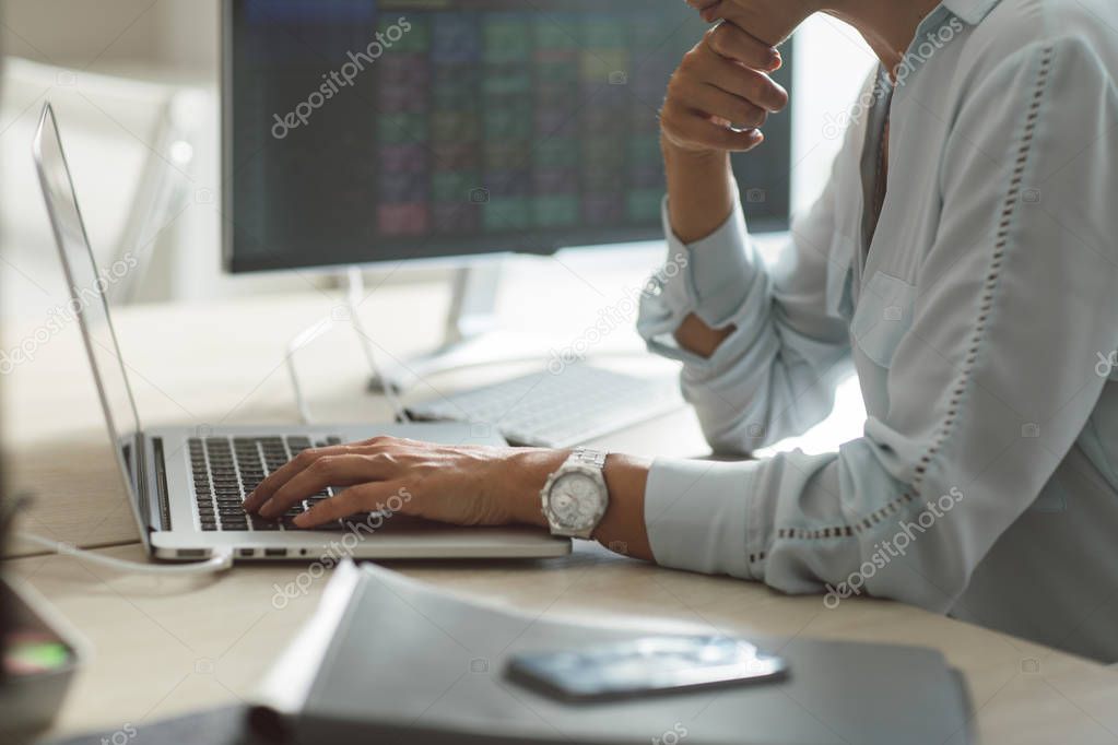 Young businesswoman working on a laptop at the modern office space.