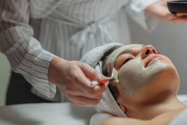 Kaukasische Kosmetikerin Trägt Eine Gesichtsmaske Auf Das Gesicht Einer Schönen — Stockfoto