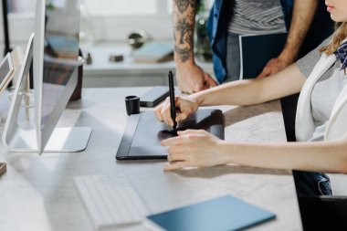 Birlikte ofiste çalışan unrecognisable erkek ve kadın grafik tasarımcıları.