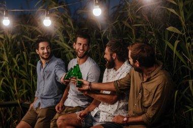 Açık ve içki bira asılı erkekler gülümseyen Genç Grup.