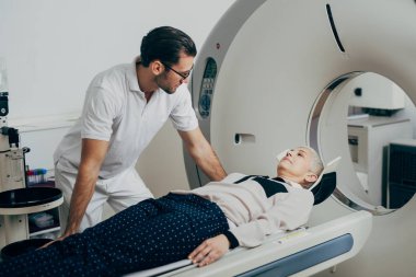 Ct tarayıcı yatakta yatıyordu onun hasta konuşurken genç tıbbi teknisyen.