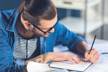 Onun ofisinde yazma genç şık beyaz adam tasarımcı.