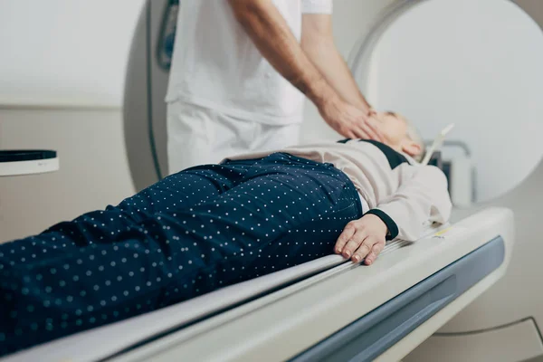 医疗技术员和他的病人躺在 扫描仪床上 抱着他的头 — 图库照片