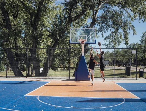 Δύο Νέοι Παίκτες Παίζοντας Μπάσκετ Στο Υπαίθριο Γήπεδο — Φωτογραφία Αρχείου