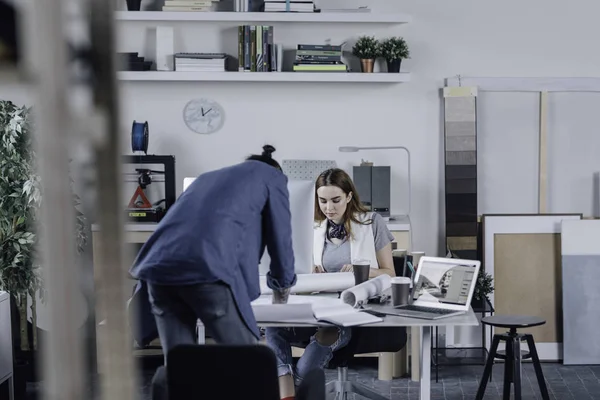 Young modern man and woman graphic designer working together at office.