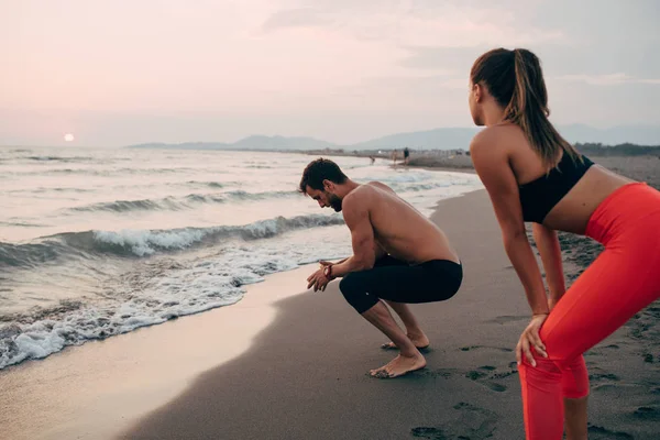 彼氏と彼女は砂浜でトレーニングを楽しんで — ストック写真