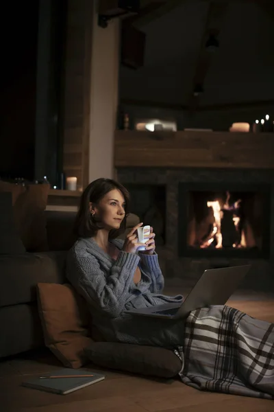 Mujer Bastante Sonriente Bebiendo Junto Chimenea Mirando Portátil Por Noche —  Fotos de Stock