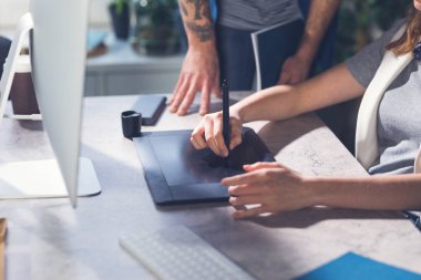 Birlikte ofiste çalışan unrecognisable erkek ve kadın grafik tasarımcıları.