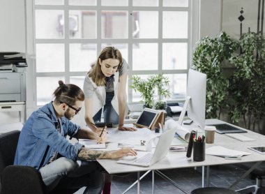 Birlikte çalışan genç erkek ve kadın tasarımcılar.