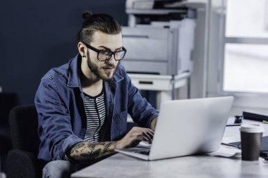 Dizüstü bilgisayarda onun ofisinde çalışan genç şık beyaz adam tasarımcı.