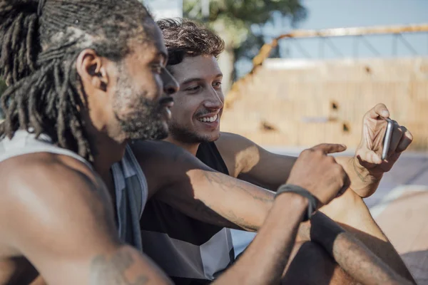 Deux Hommes Regardant Téléphone Portable Assis Sur Terrain Basket Plein — Photo