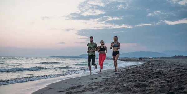 Gruppo Atleti Che Corrono Insieme Sulla Spiaggia Sabbia — Foto Stock