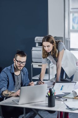 Birlikte çalışan genç erkek ve kadın tasarımcılar.