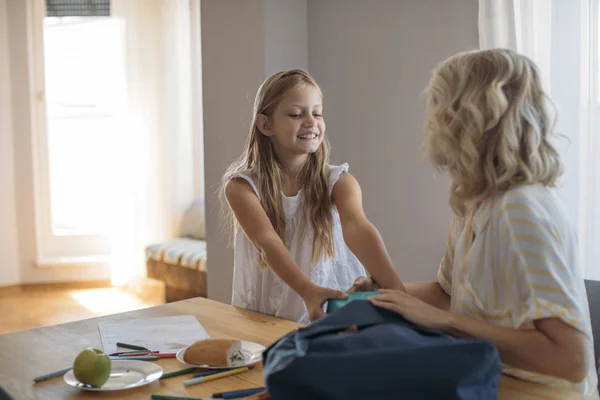 Hermosa Chica Empacando Mochila Escolar Con Madre —  Fotos de Stock