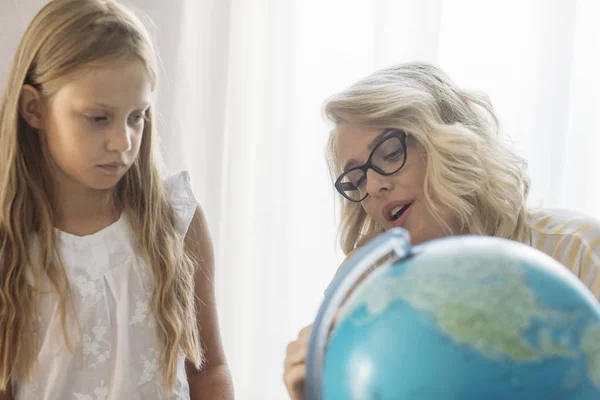 美丽的金发女子教地理地球上一个可爱的白种女孩 — 图库照片