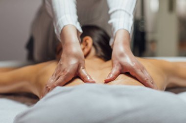 genç kadının bir spa merkezinde bir sırt masajı.