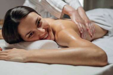 genç kadının bir spa merkezinde bir sırt masajı.