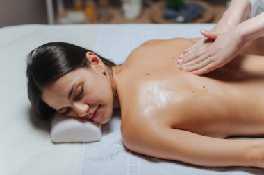 genç kadının bir spa merkezinde bir sırt masajı.