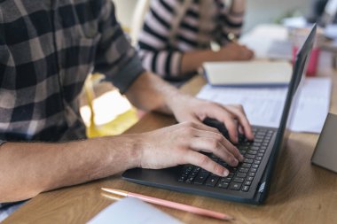 Elleri onun dizüstü bilgisayarda yazarak unrecognisable gencin.