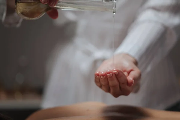 Masseuse Massageolie Gieten Haar Hand Bij Een Kuuroord — Stockfoto