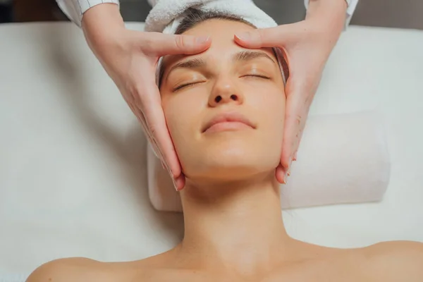 Jeune Femme Bénéficiant Massage Facial Dans Centre Spa Photo De Stock