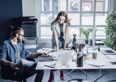 Genç erkek ve kadın tasarımcılar planları ile çalışma.