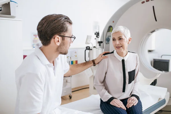 Jovem Técnico Médico Conversando Com Paciente Enquanto Senta Leito Tomógrafo — Fotografia de Stock