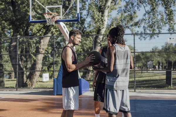 三个年轻人站在室外篮球场上 — 图库照片