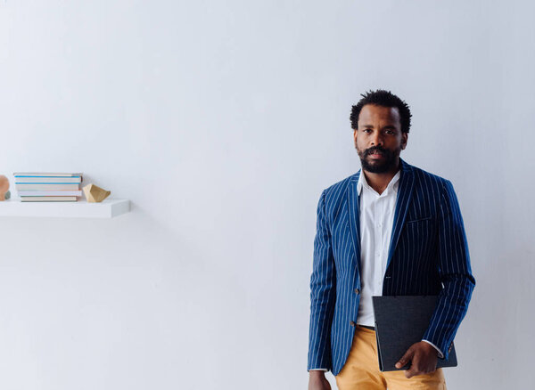 Красивый африканский стильный бизнесмен смотрит в камеру
.