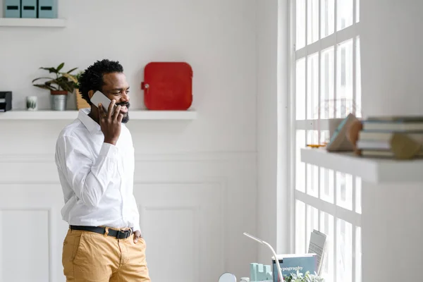 Guapo Africano Sonriente Hombre Negocios Pie Oficina Hablando Por Teléfono — Foto de Stock