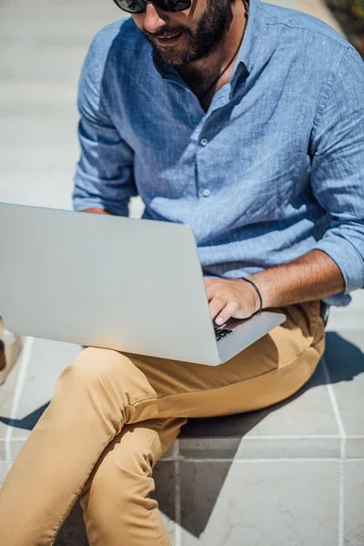 Bankta oturan ve onun dizüstü bilgisayarda çalışan yakışıklı beyaz adam serbest meslek.