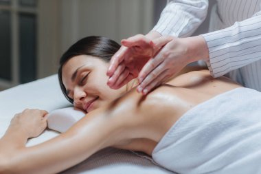 genç kadının bir spa merkezinde bir sırt masajı.