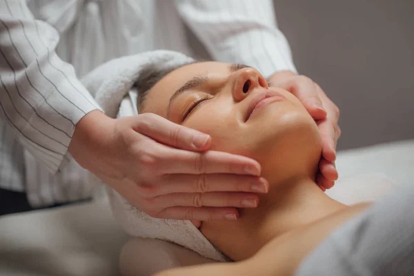 Mujer Joven Disfrutando Masaje Facial Centro Spa —  Fotos de Stock