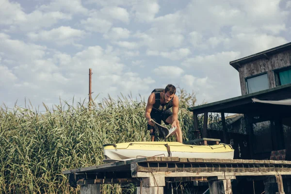 Joven Hombre Caucásico Llevando Chaleco Salvavidas Moviendo Kayak Muelle Madera — Foto de Stock