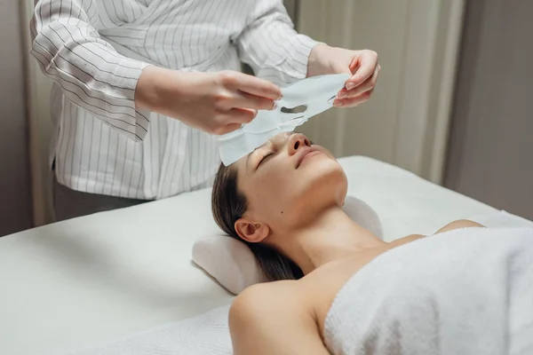 Mulher Cosmetologista Caucasiana Colocando Uma Máscara Facial Rosto Uma Bela — Fotografia de Stock